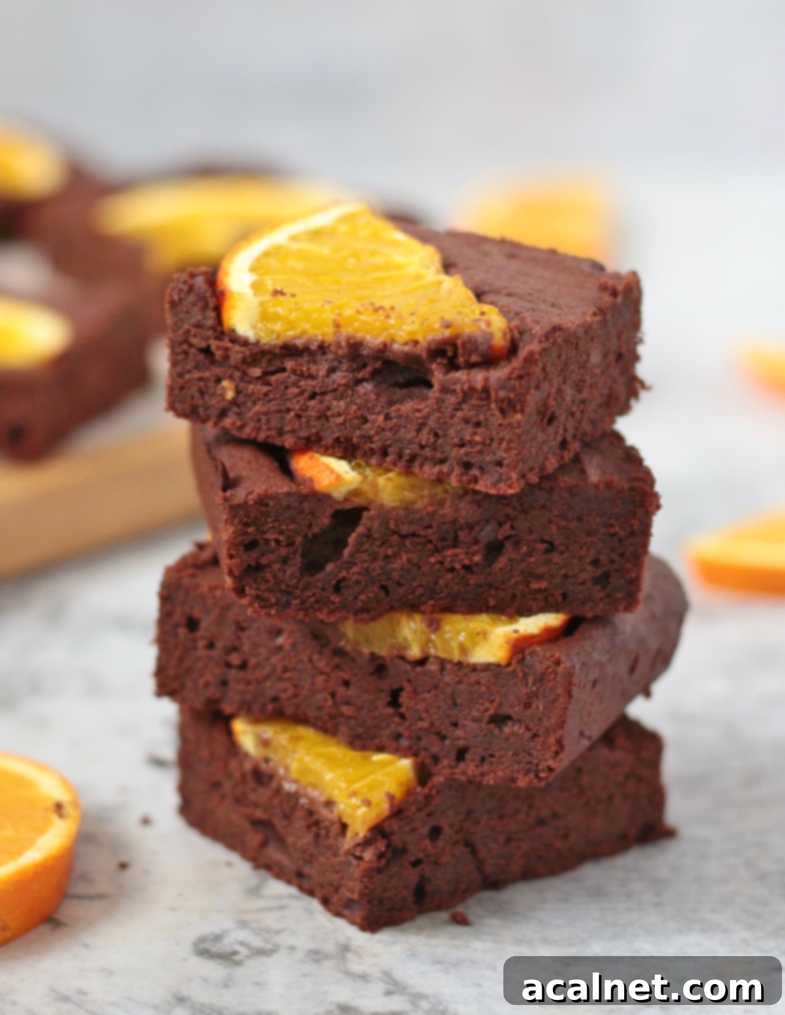A stack of four rich Chocolate Orange Brownies, showcasing their fudgy texture.