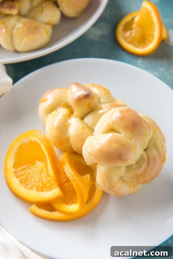 Beautifully arranged Knotted Orange Sweet Rolls with a glossy citrus glaze.
