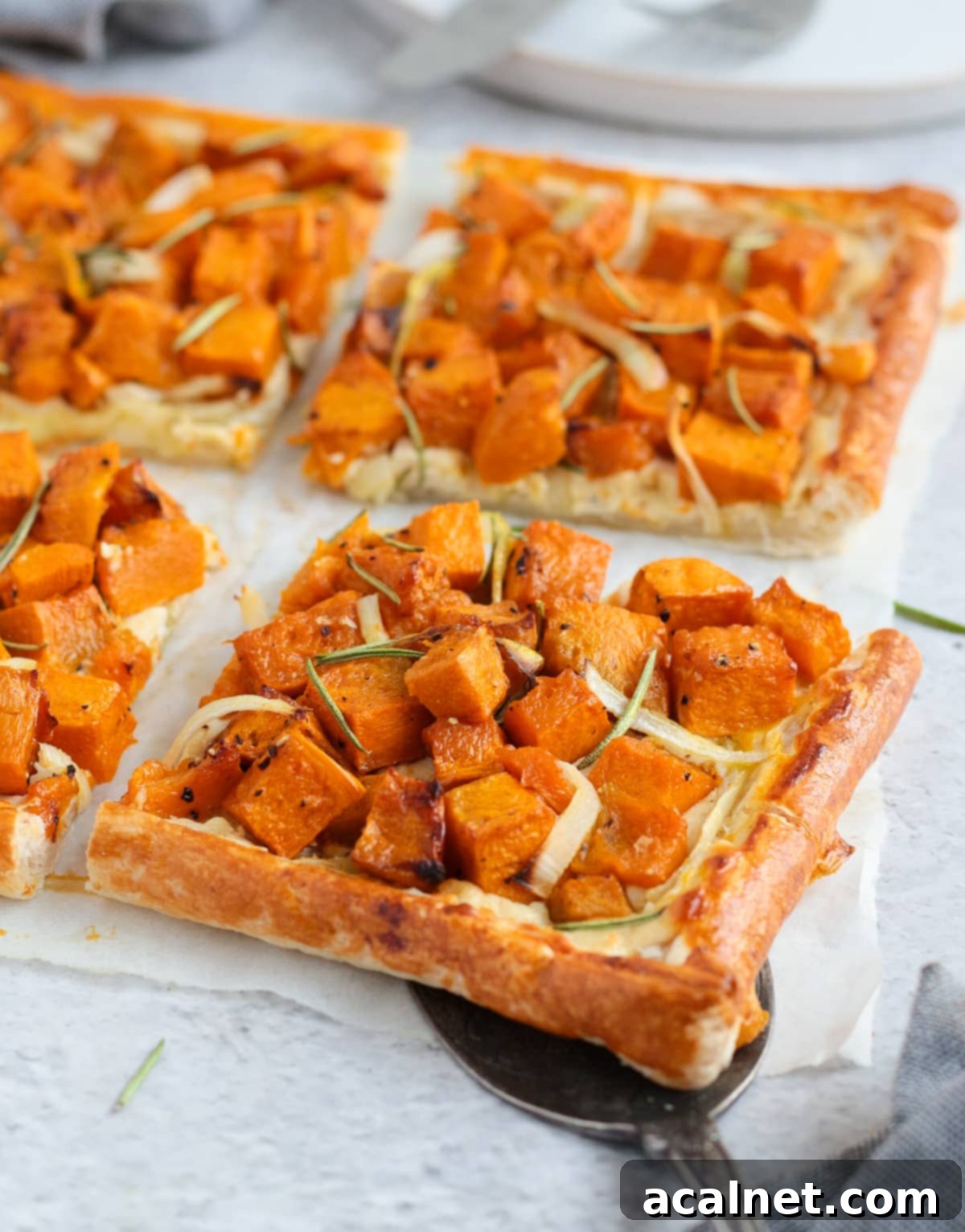 Four slices of Savory Pumpkin Tart arranged on baking paper