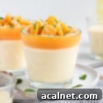 Close up on a panna cotta in a small glass cup placed over a white plate