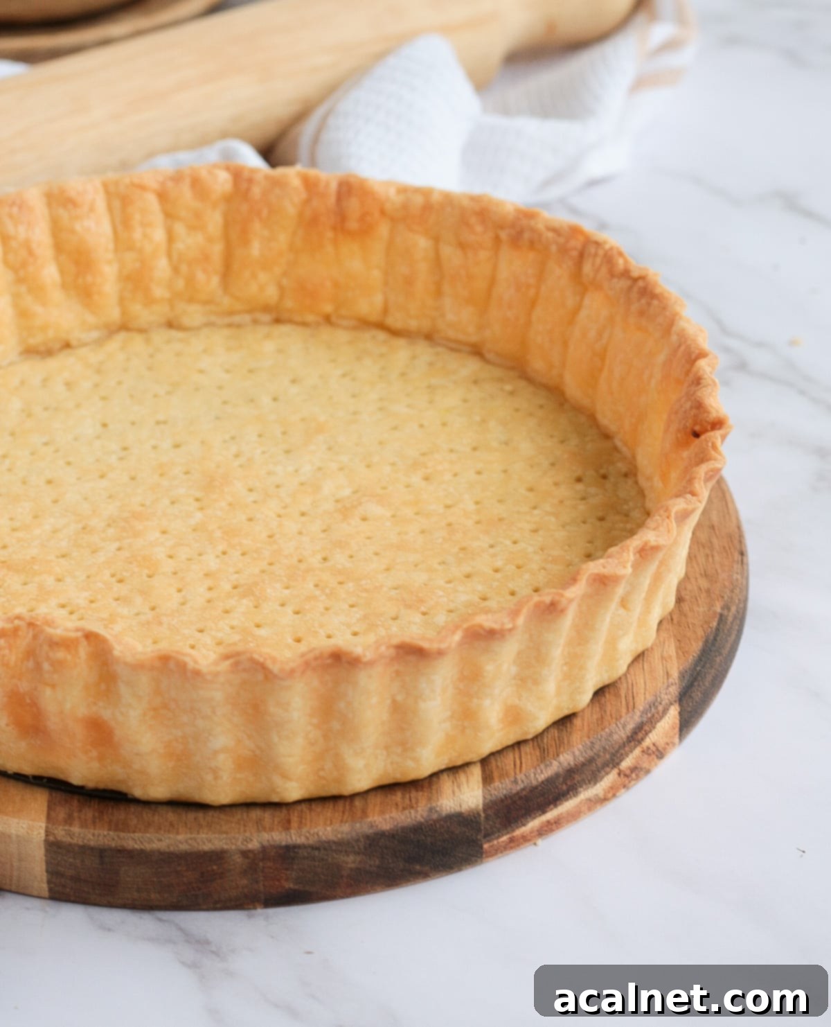 Side view on the blind baked crust over a round wooden board
