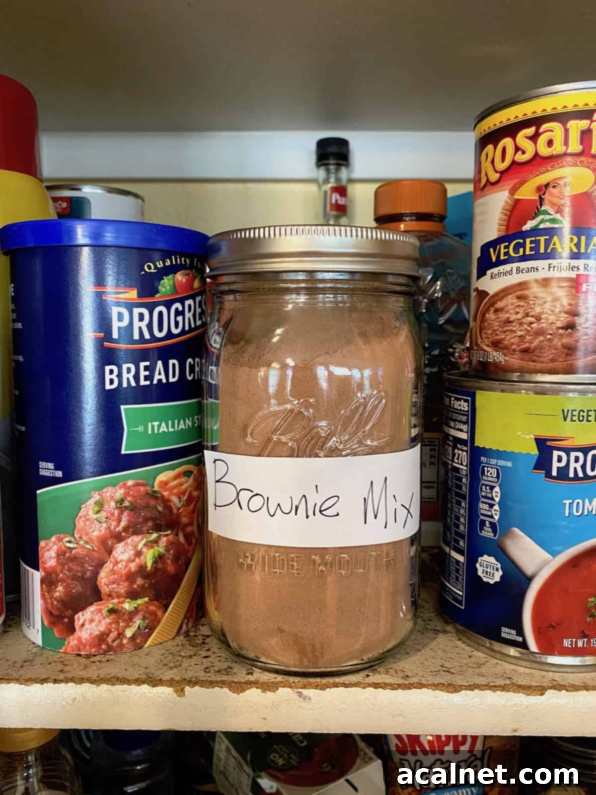 A jar of brownie mix on a pantry shelf.