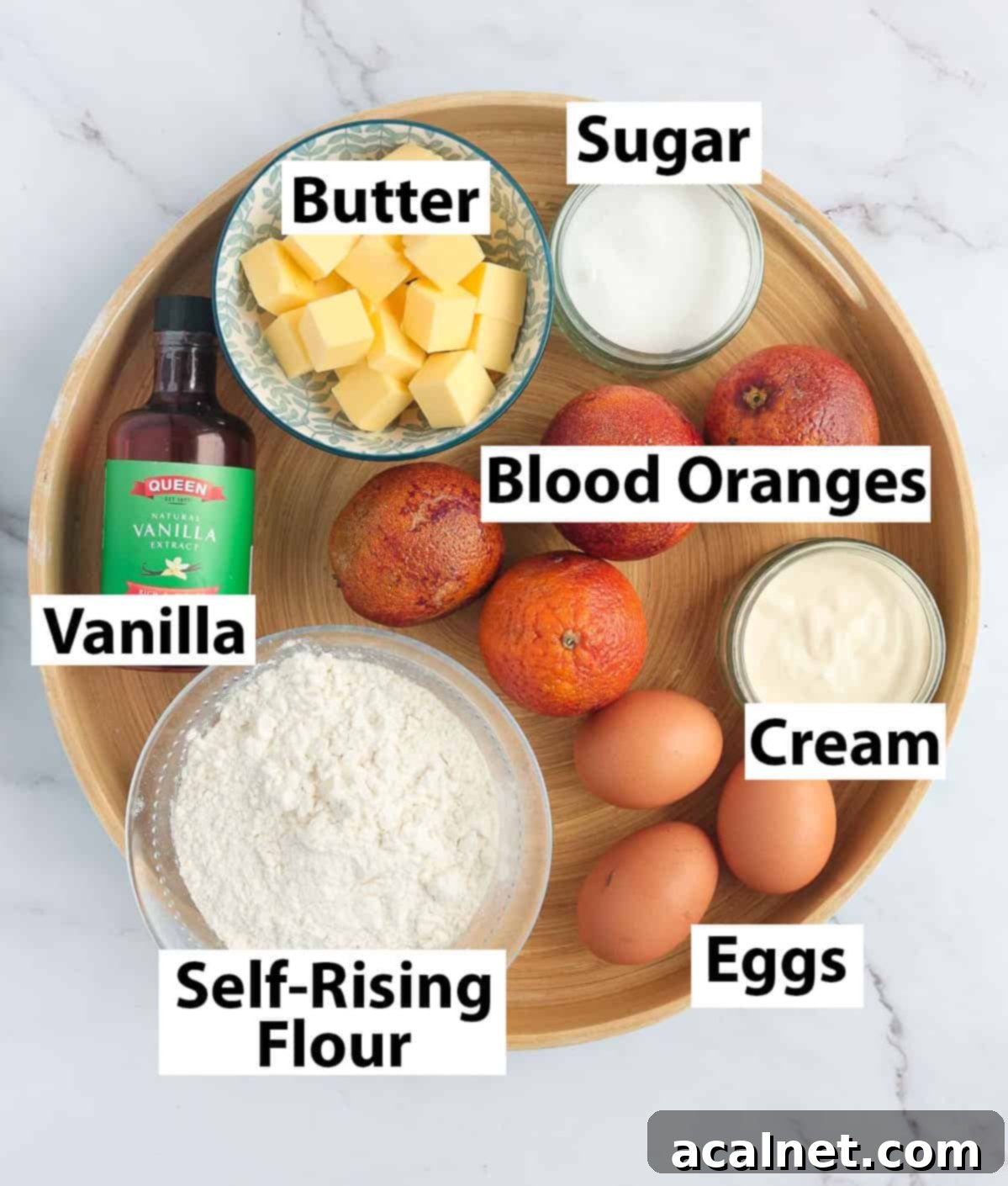 Recipe ingredients for Blood Orange Upside Down Cake arranged in a round wooden tray.