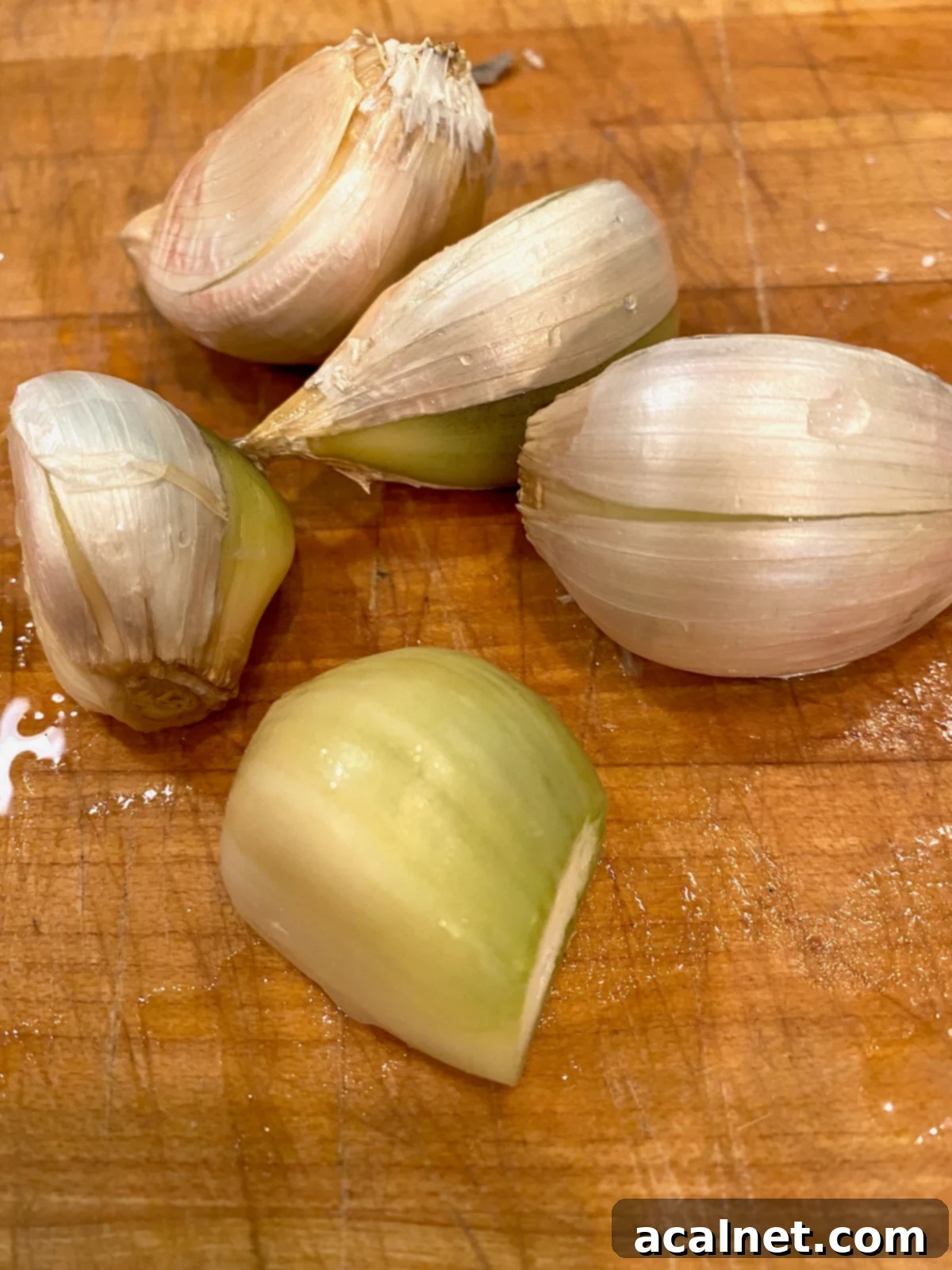 Sweet Potato Lasagna Perfection 16 Several large elephant garlic cloves resting on a wooden cutting board.