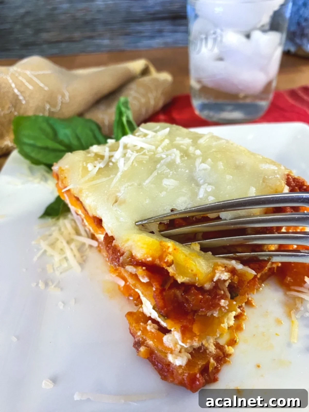 Sweet Potato Lasagna Perfection 8 A beautiful, individual wedge of sweet potato lasagna plated with a fork, emphasizing its tender layers and rich texture.