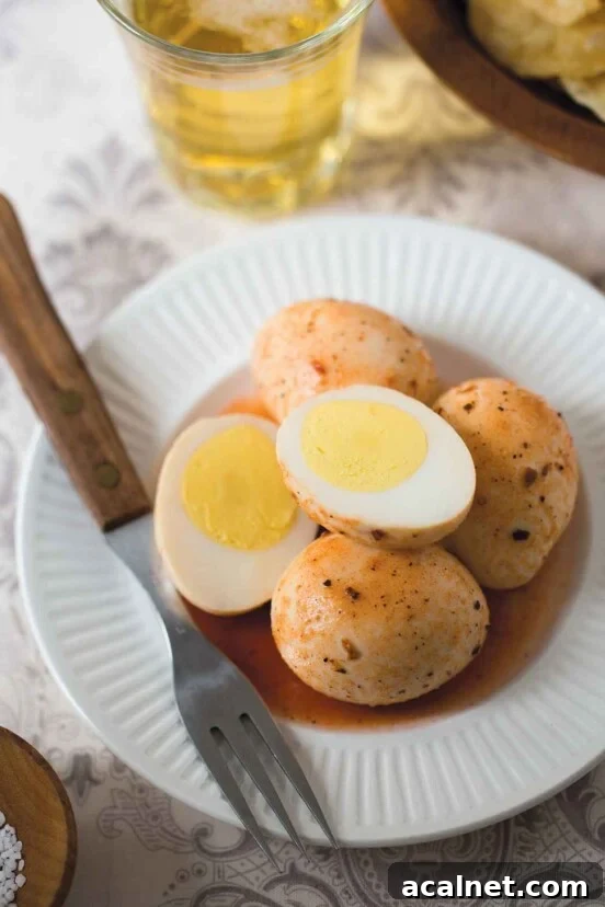 A white plate topped with four Cajun pickled eggs, one of which is cut in half. A fork rests on the plate.
