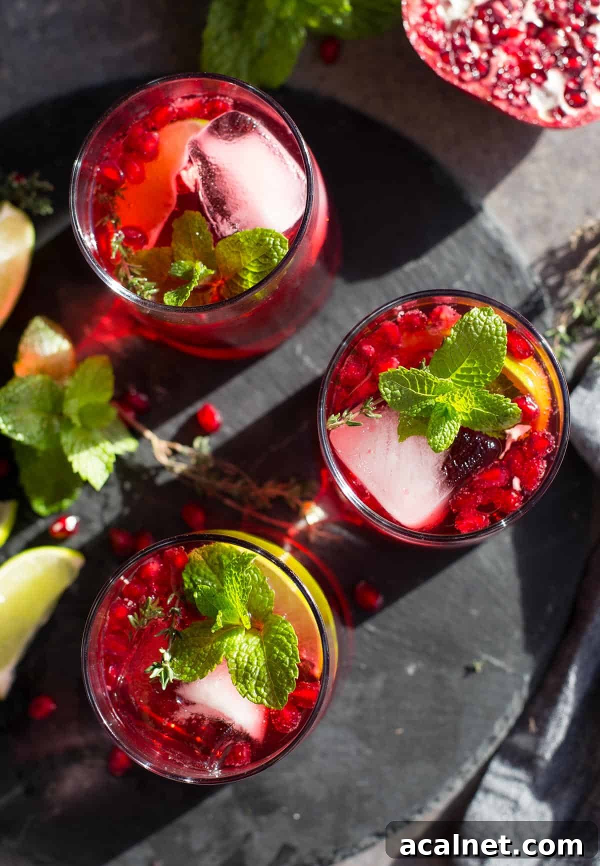Pomegranate Ginger Beer Cocktail Recipe: Sparkling Holiday Drink 4 Three festive holiday cocktails on a black slate serving platter