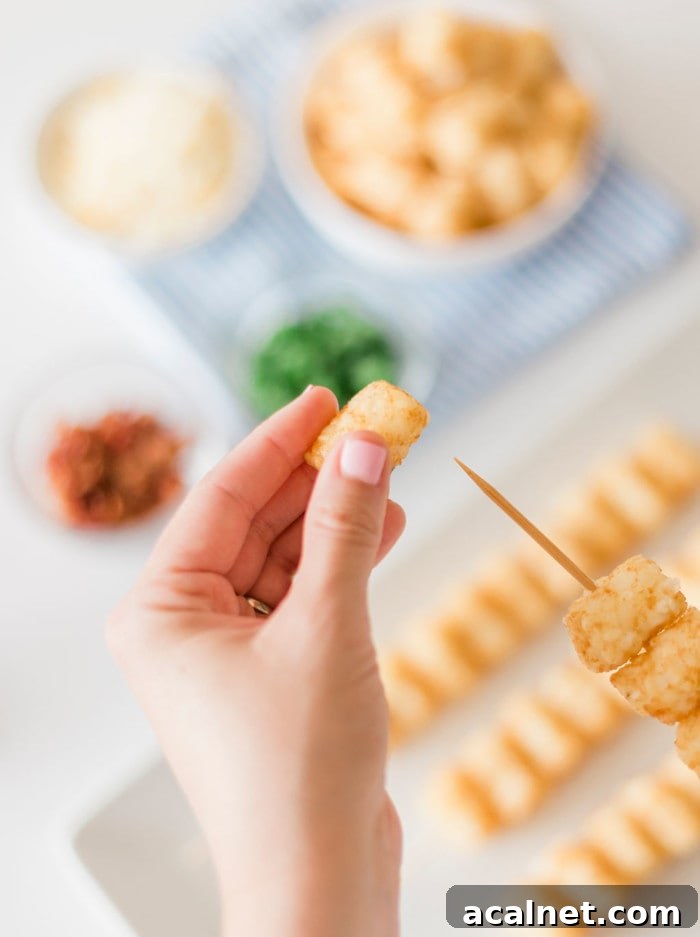 Hand threading tater tots onto skewers