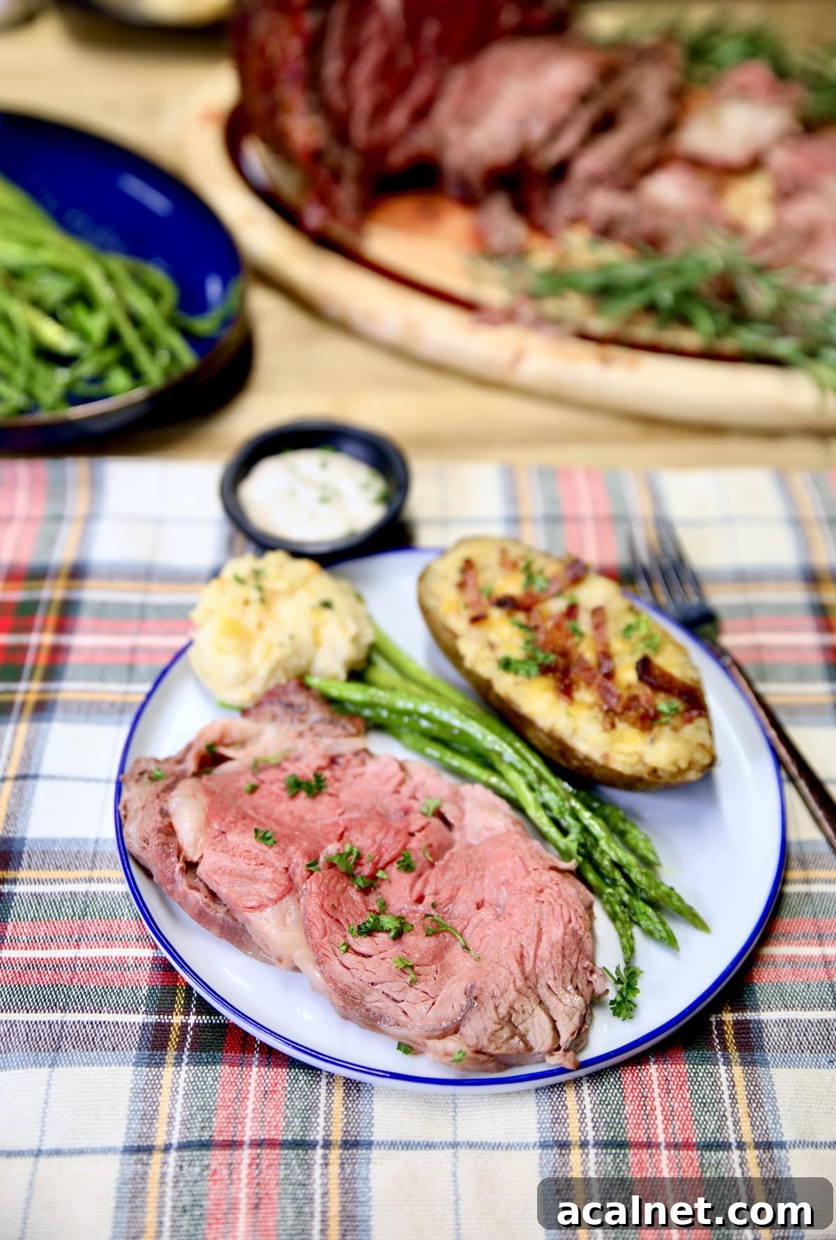 Christmas prime rib roast. Easy grilling recipe cooked in 2 hours. Plate of rare prime rib, potato, asparagus.