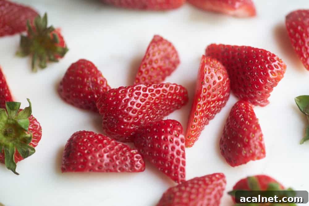 Dairy-Free Strawberry Milkshake Recipe: Creamy Vegan Shake 3 Fresh strawberry slices on a marble cutting board.