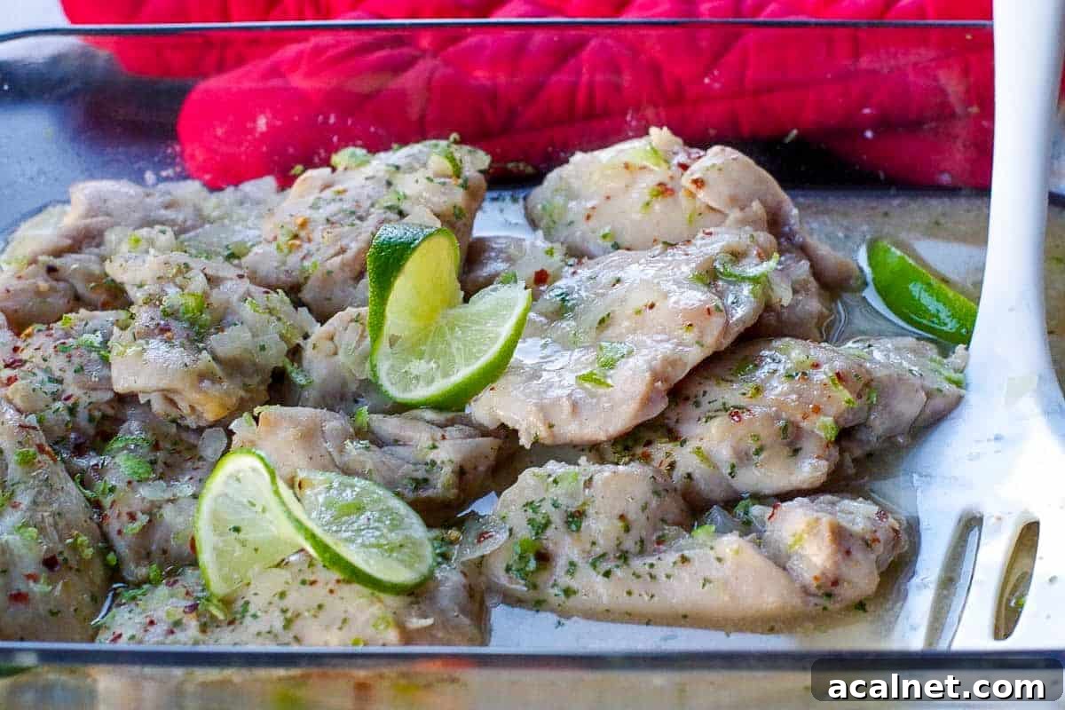 honey lime chicken in a glass casserole dish with carrots and rice in the background