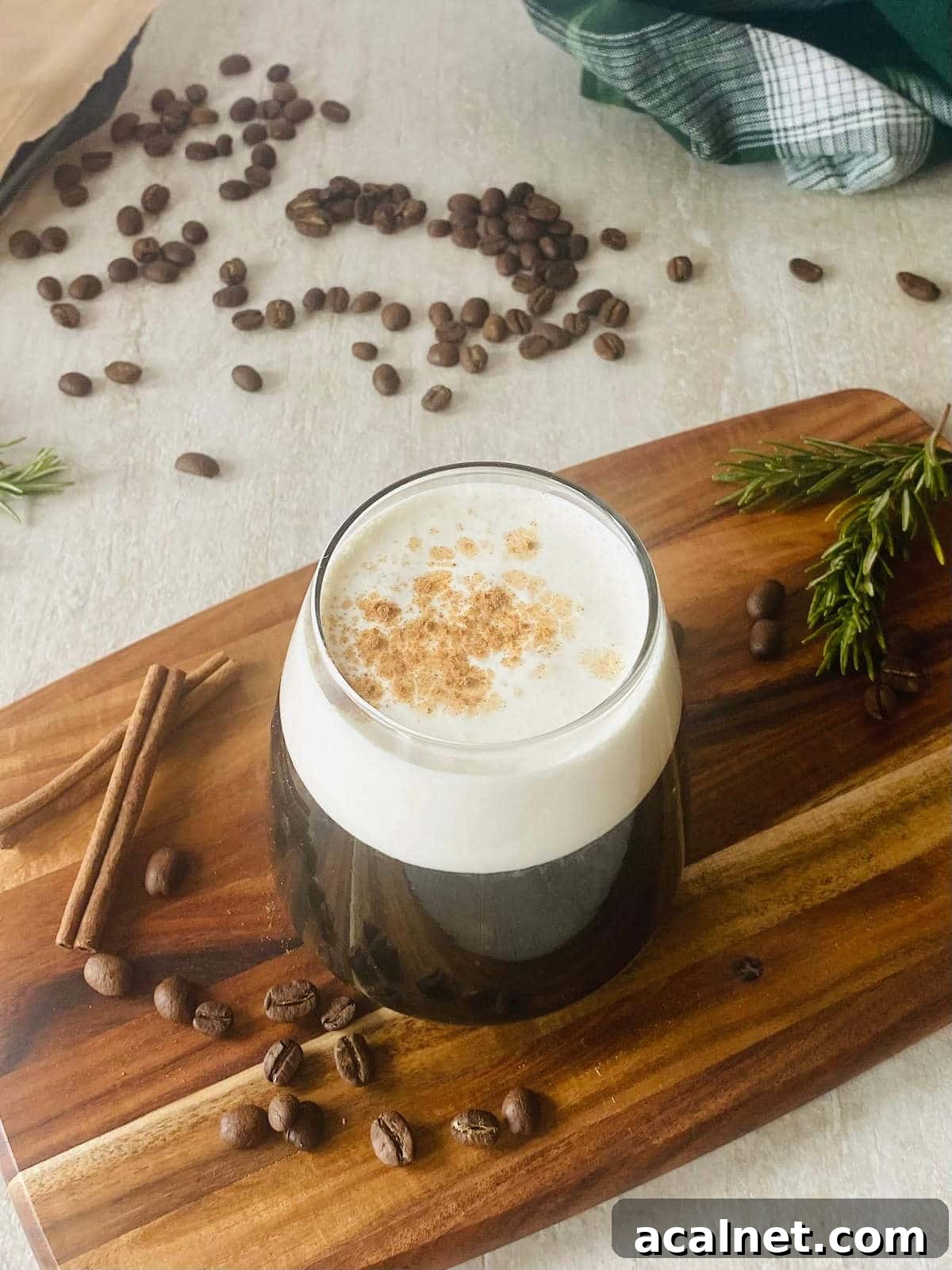 How to Make Sweet Cream Cold Foam for Coffee Drinks 5 starbucks sweet cream cold brew coffee next to coffee beans and cinnamon sticks.