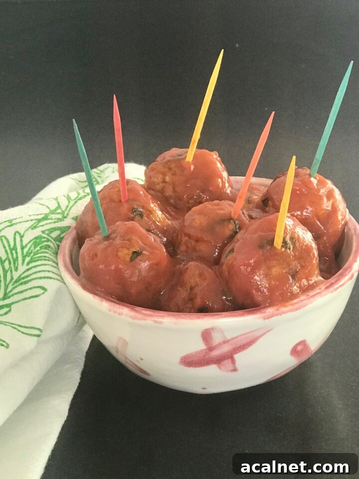 Vegan Sweet and Sour Meatballs in a small dish with colorful toothpics.