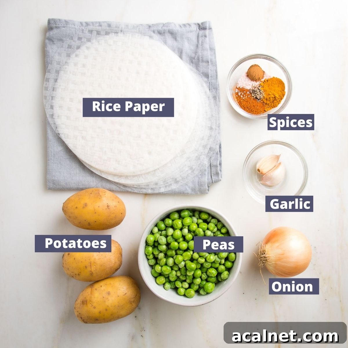 Labeled ingredients for baked samosa recipe: Rice paper wrappers, spices, garlic, onion, green peas and yukon gold potatoes