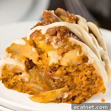 pumpkin apple spice Bundt Cake topped with cream cheese glaze on a white plate.