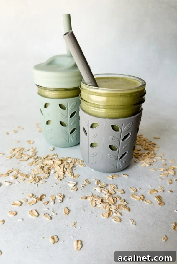 Spinach banana smoothies in toddler glass tumblers with silicone sleeves.