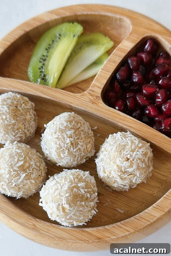 Coconut balls served with kiwi chunks and pomegranate seeds.