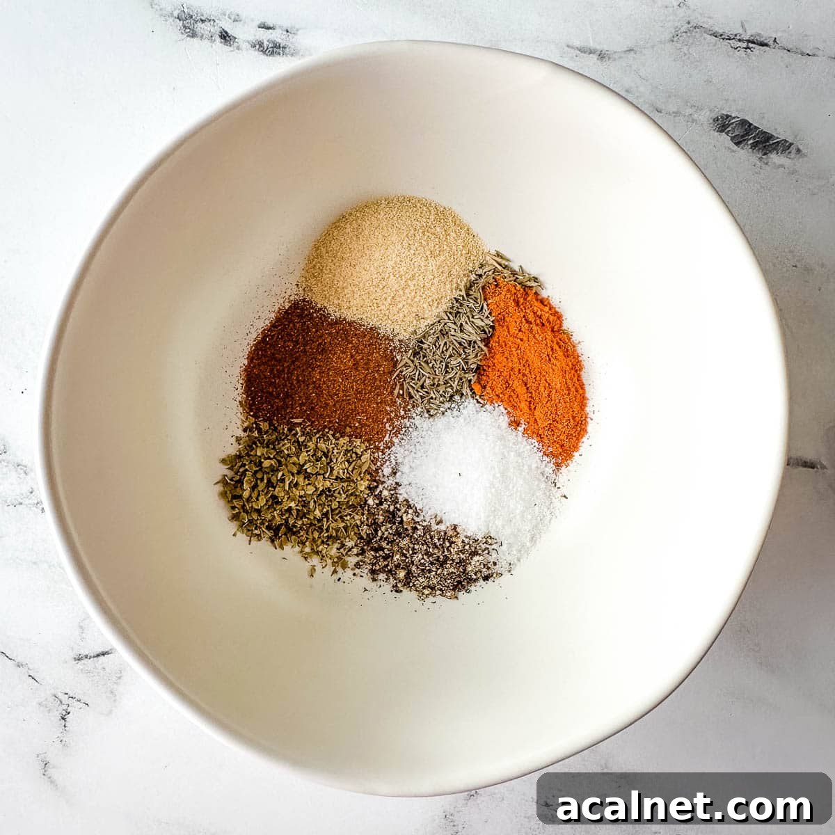Ingredients for blackening seasoning in a white bowl.