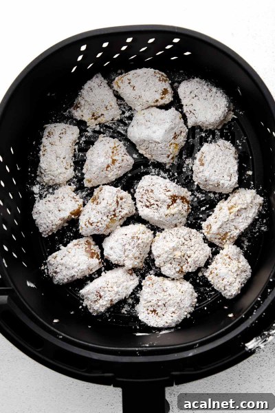coated chicken chunks in air fryer basket