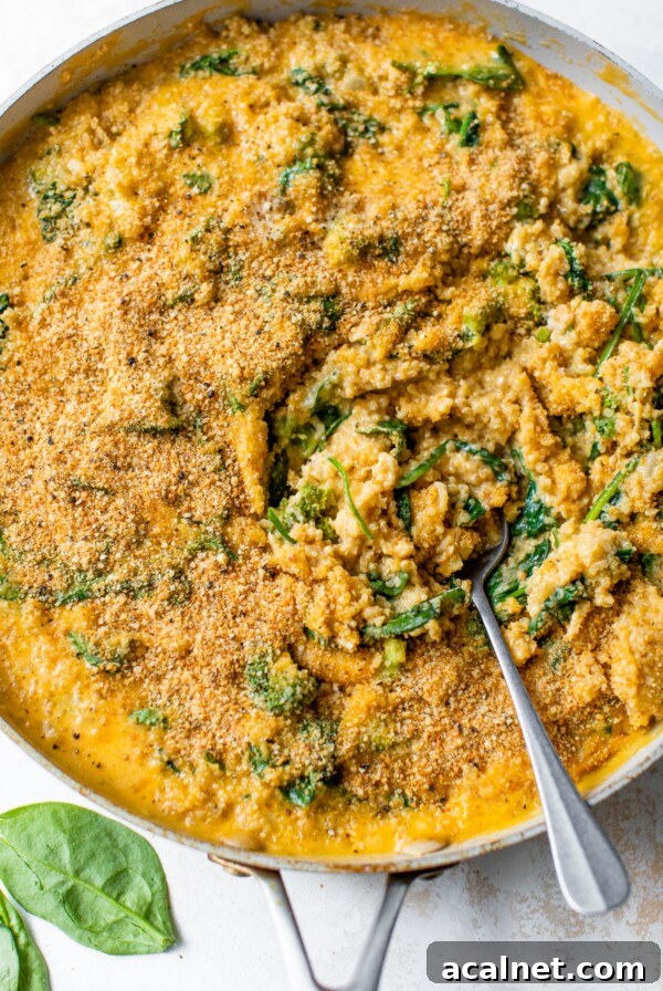 mac and cheese with quinoa and spinach in a skillet