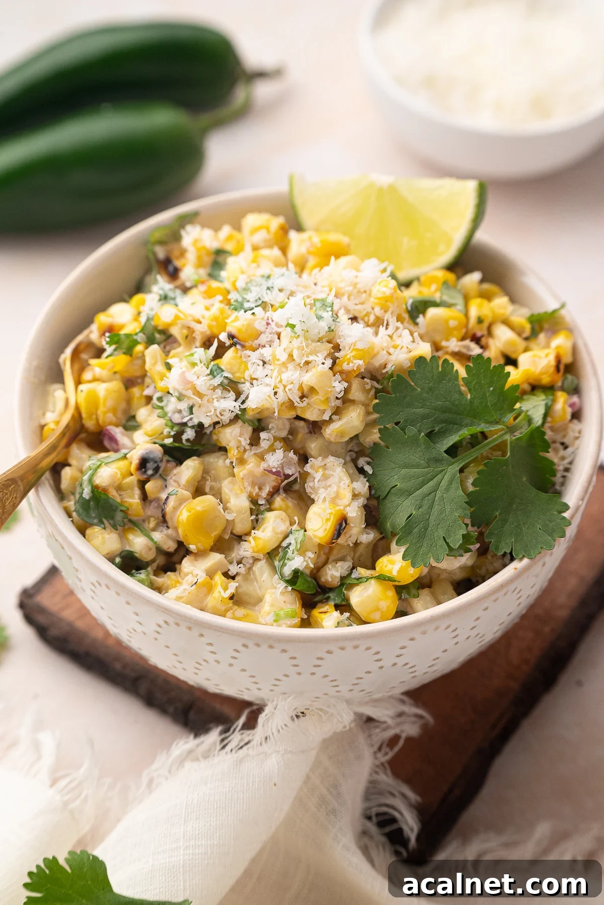 white bowl filled with Mexican corn salad garnished with lime and cilantro