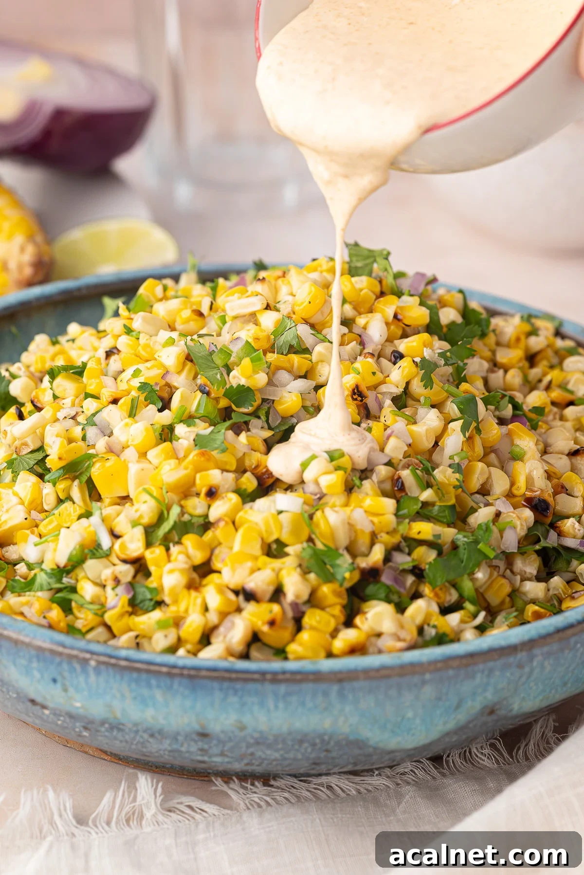 pouring dressing on street corn salad