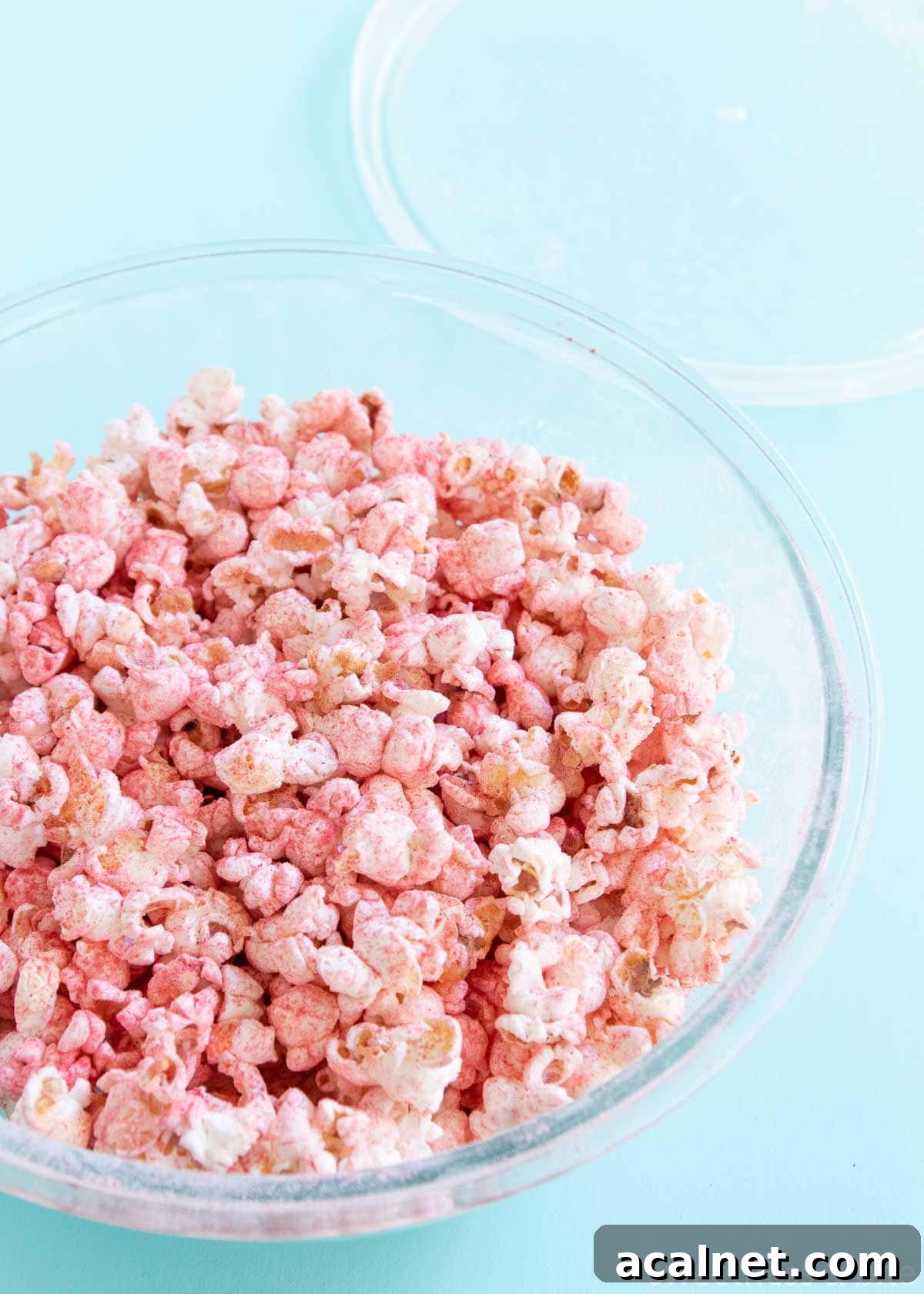 Glass bowl with the popcorn and fruit powder all mixed up.