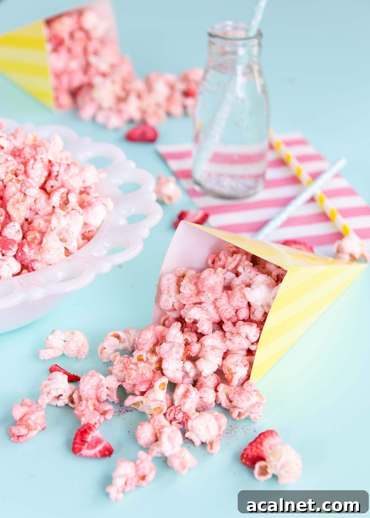 Flavoured popcorn in a yellow and white striped paper cone.