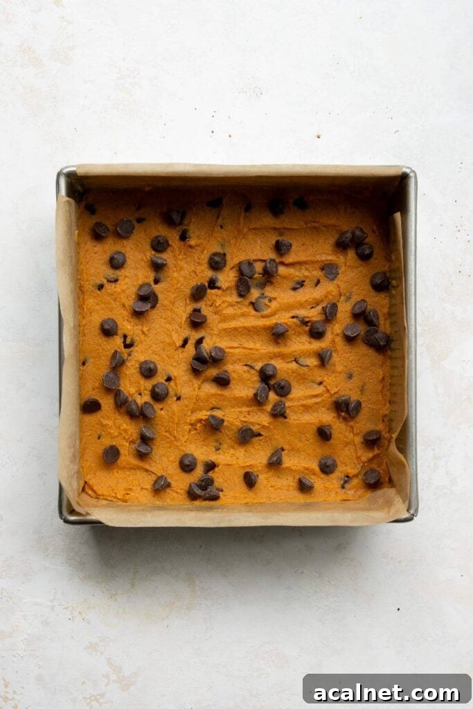 unbaked sweet potato blondies in a baking dish with chocolate chips on top
