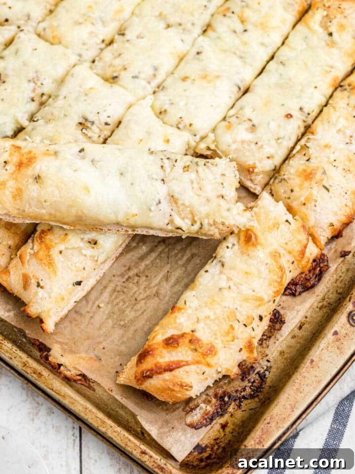 Square shot of an italian cheese bread with one taken out.