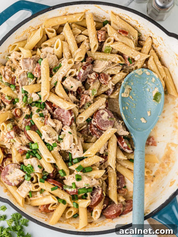 A large skillet filled with Cajun Chicken and Sausage pasta.