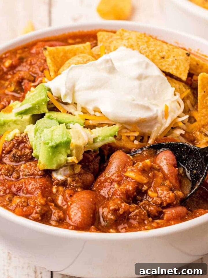 close up of a bowl of venison chili with beans and sour cream on top