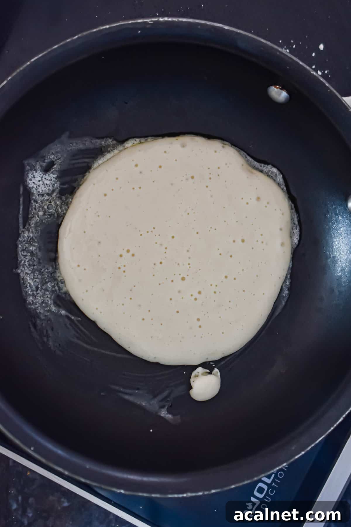 Fluffy Pancakes Made with Cake Flour: Light, Tender Stacks 7 A scoop of the pancakes with cake flour batter is in a pan.