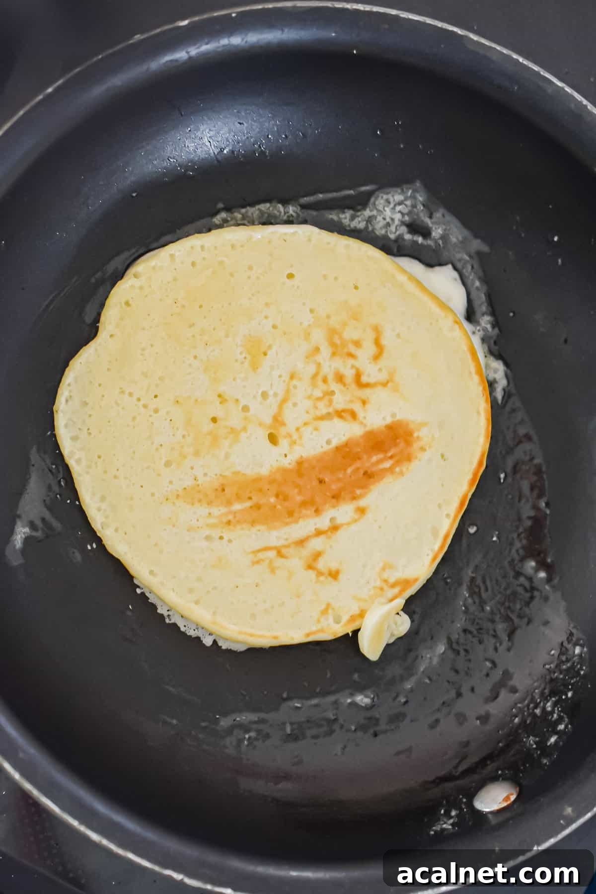 Fluffy Pancakes Made with Cake Flour: Light, Tender Stacks 8 The pancake is flipped in a pan.