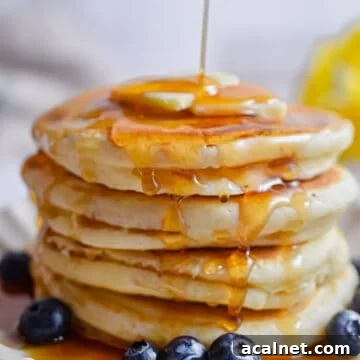 Fluffy Pancakes Made with Cake Flour: Light, Tender Stacks 10 Maple syrup is being poured onto the pancakes.