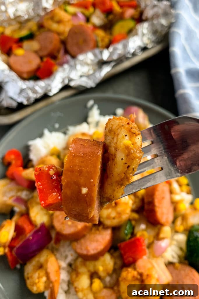 Close up of cajun shrimp and sausage on a fork.
