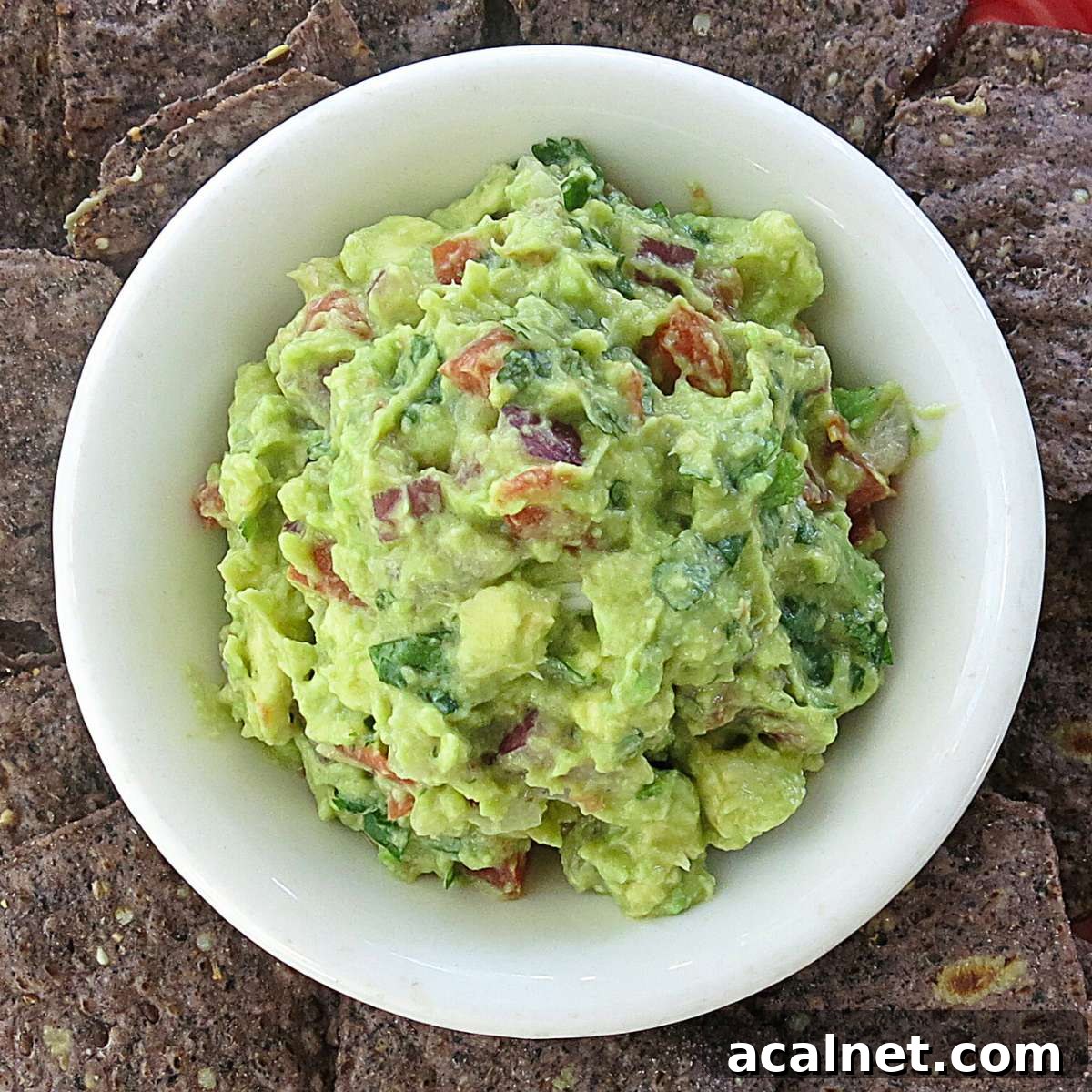 4-Ingredient guacamole in a bowl surrounded by chips.