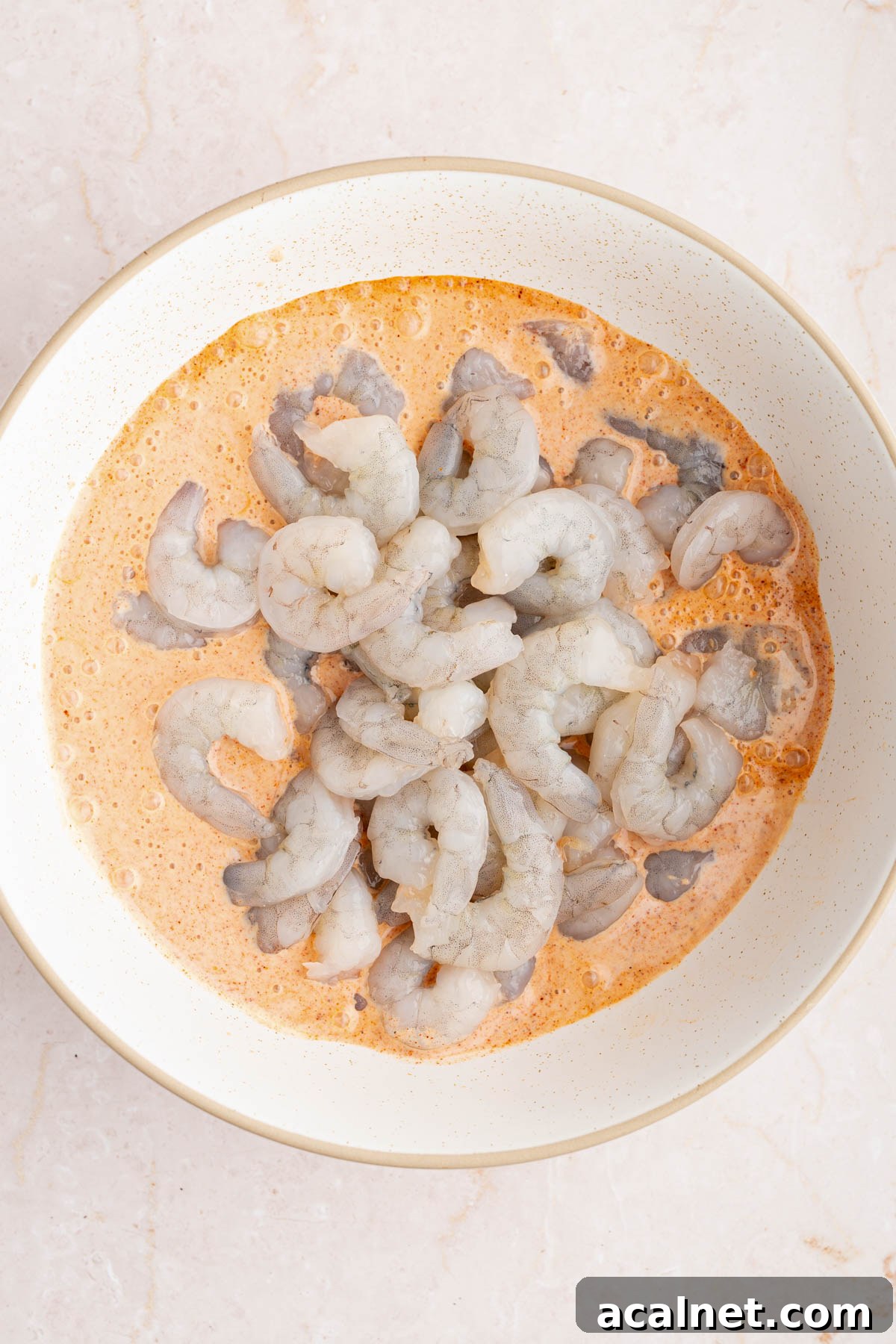 Crispy Shrimp Po' Boy Sandwich Recipe for Classic New Orleans Flavor 4 The shrimp in a large white bowl with the buttermilk sauce.