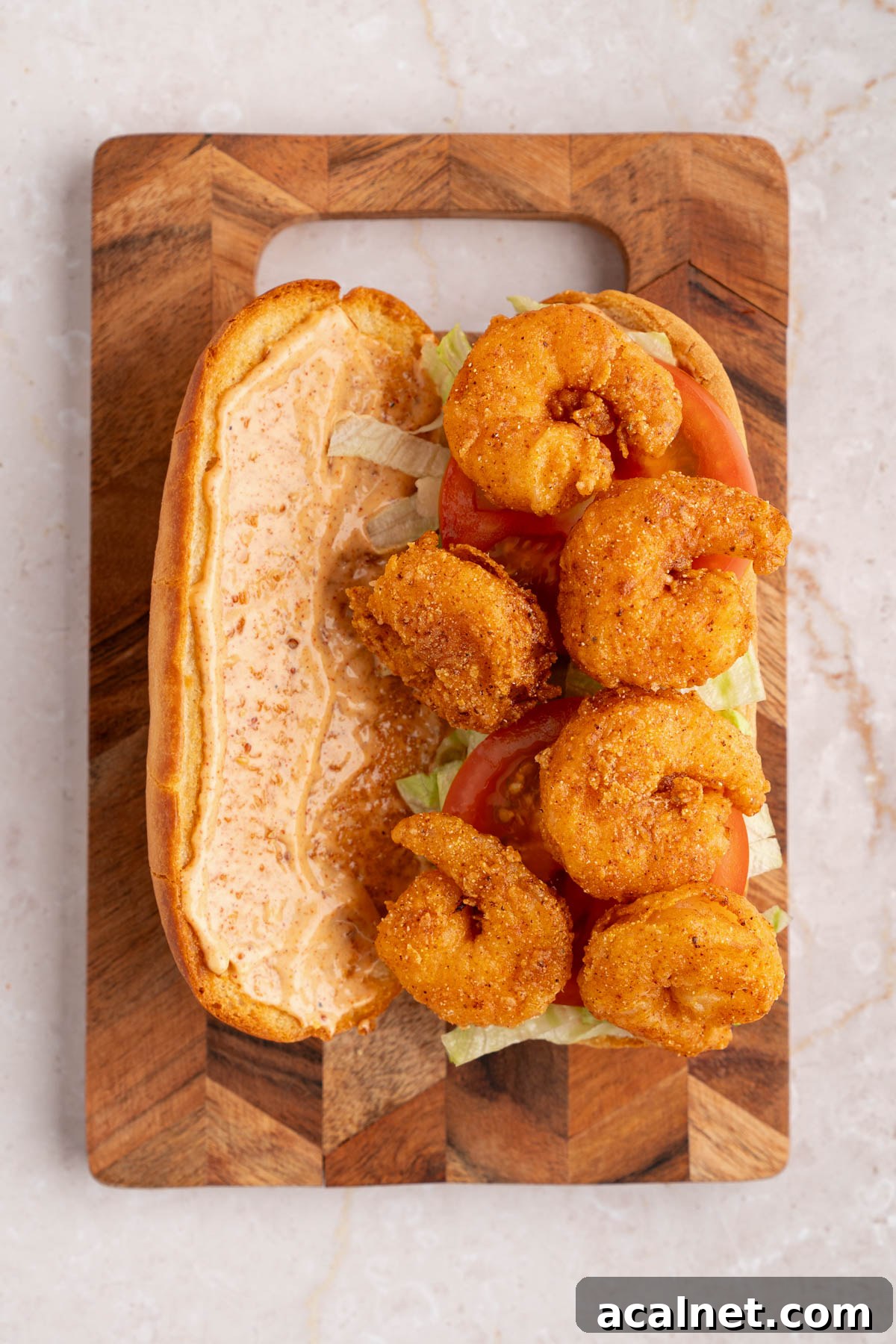 Crispy Shrimp Po' Boy Sandwich Recipe for Classic New Orleans Flavor 10 The lettuce, tomato, and fried shrimp layered on a french roll that is spread with the remoulade sauce.