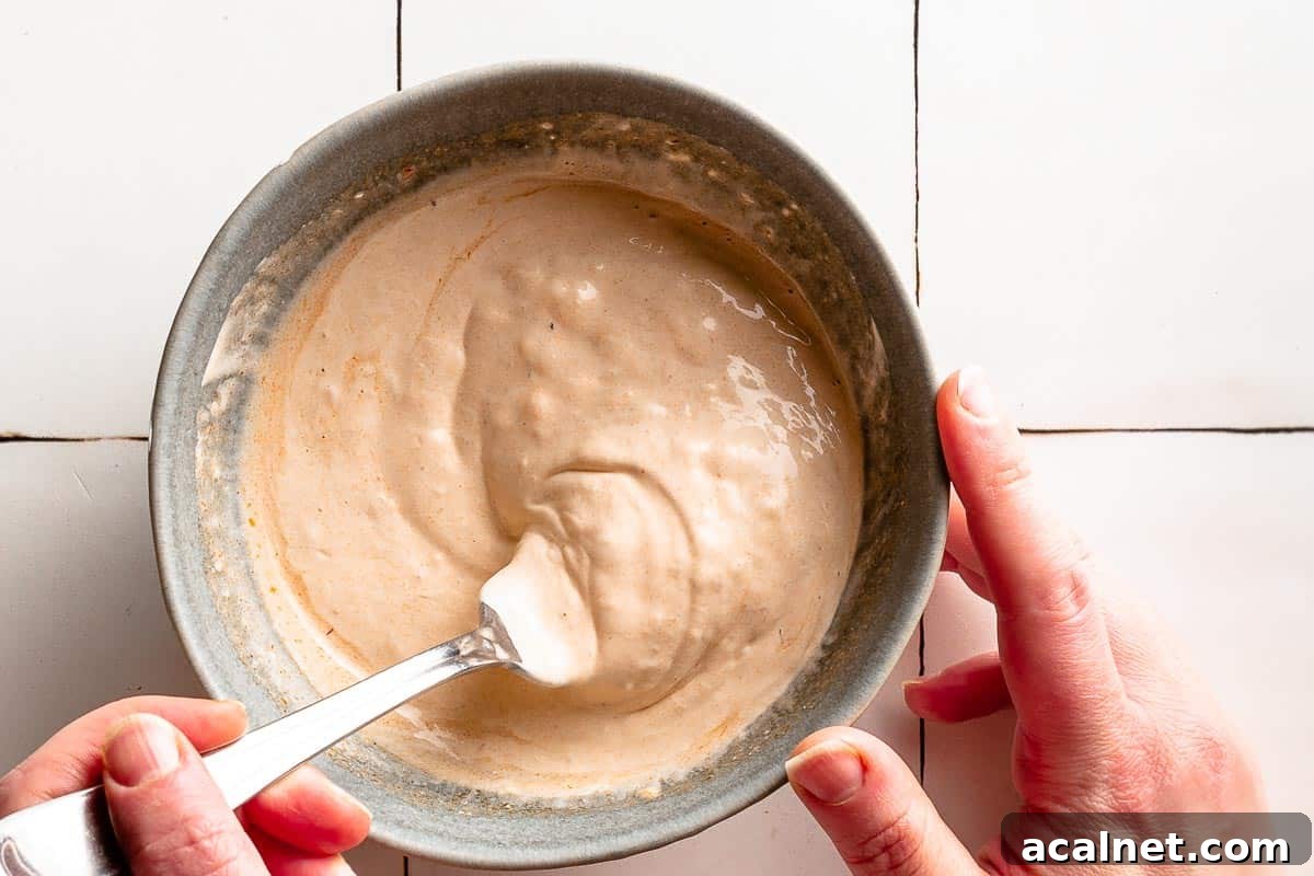 creamy chipotle sauce being mixed with fork in bowl