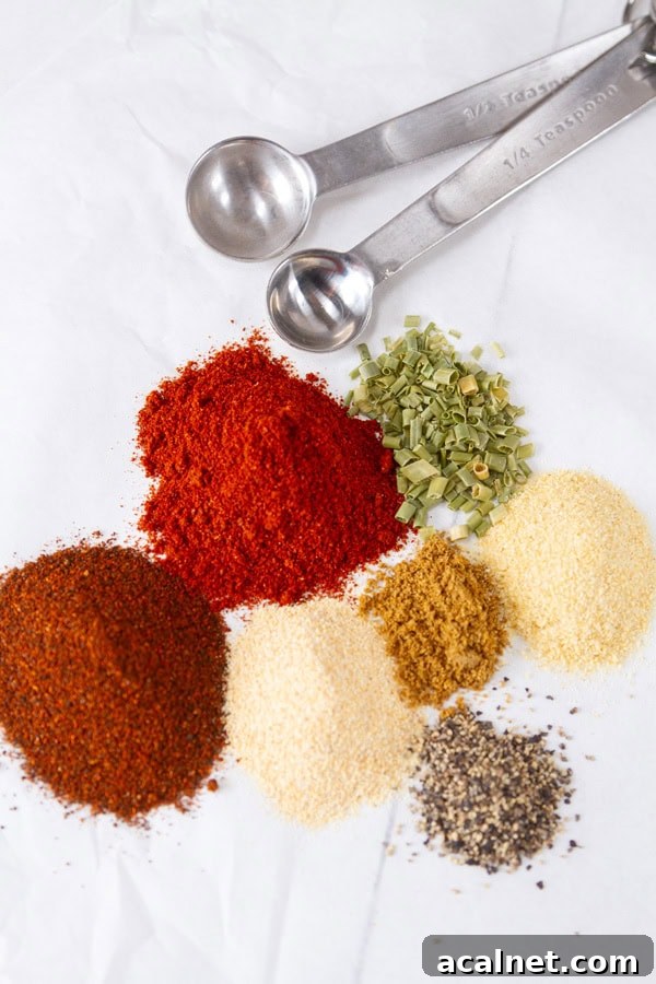 spices measured out and some measuring spoons next to them.