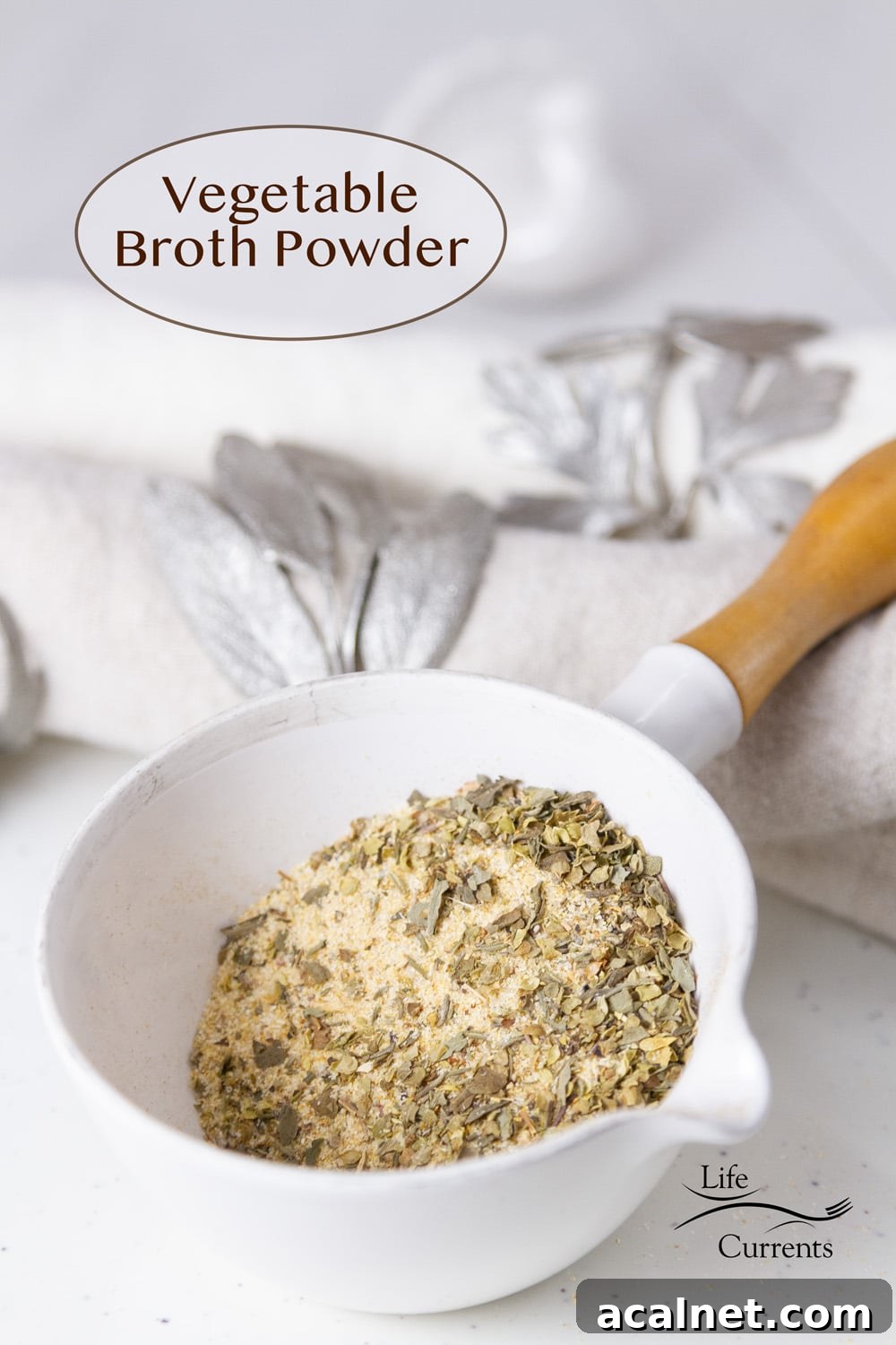 a small measuring cup filled with Vegetable Broth Powder next to a towel