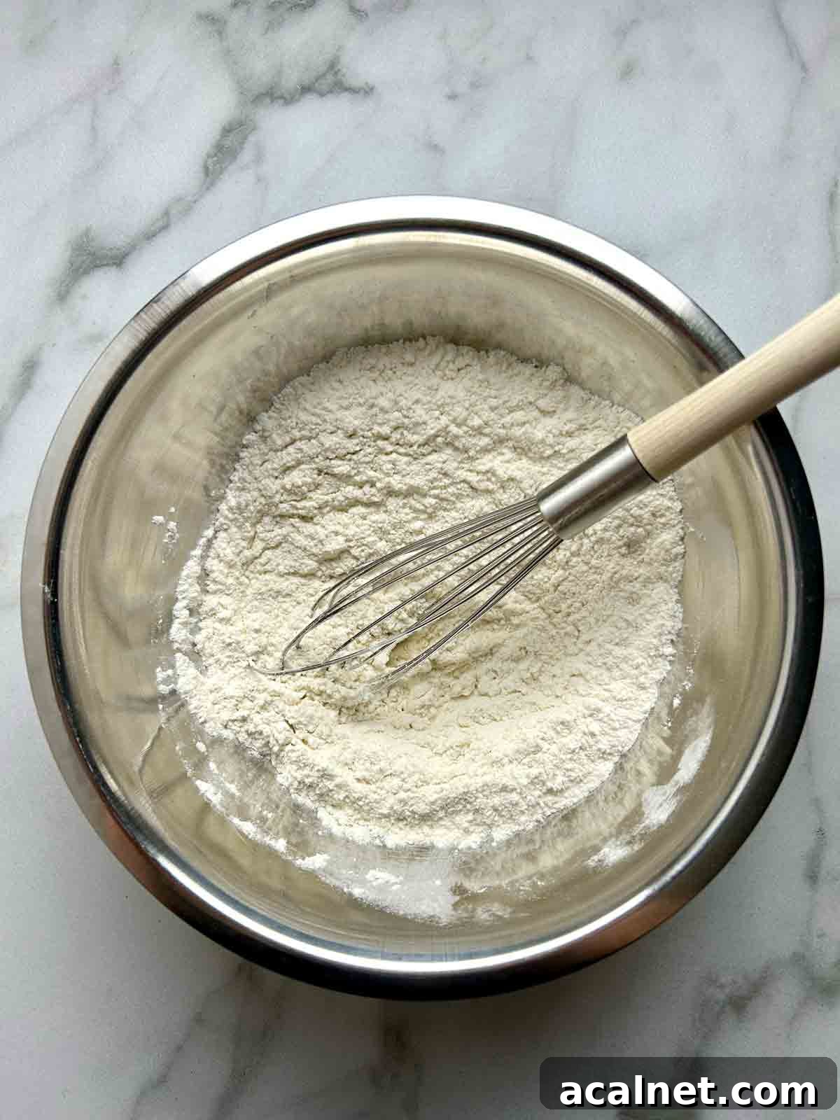 dry ingredient being whisked in bowl.