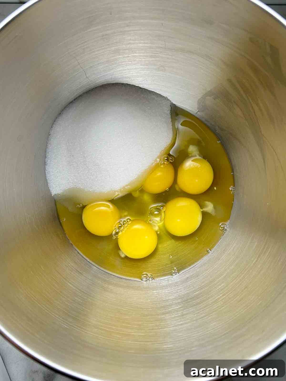 eggs and sugar unmixed in stand mixer bowl.