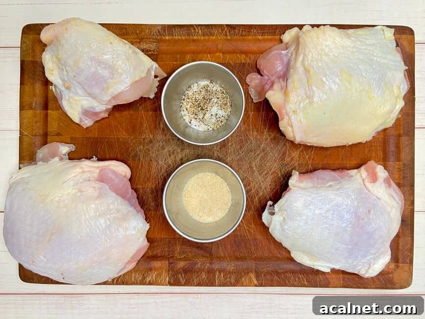 Spicy Buffalo Chicken Thighs with Crispy Skin and Blue Cheese Dip 3 Chicken thighs and spices on a wood cutting board.