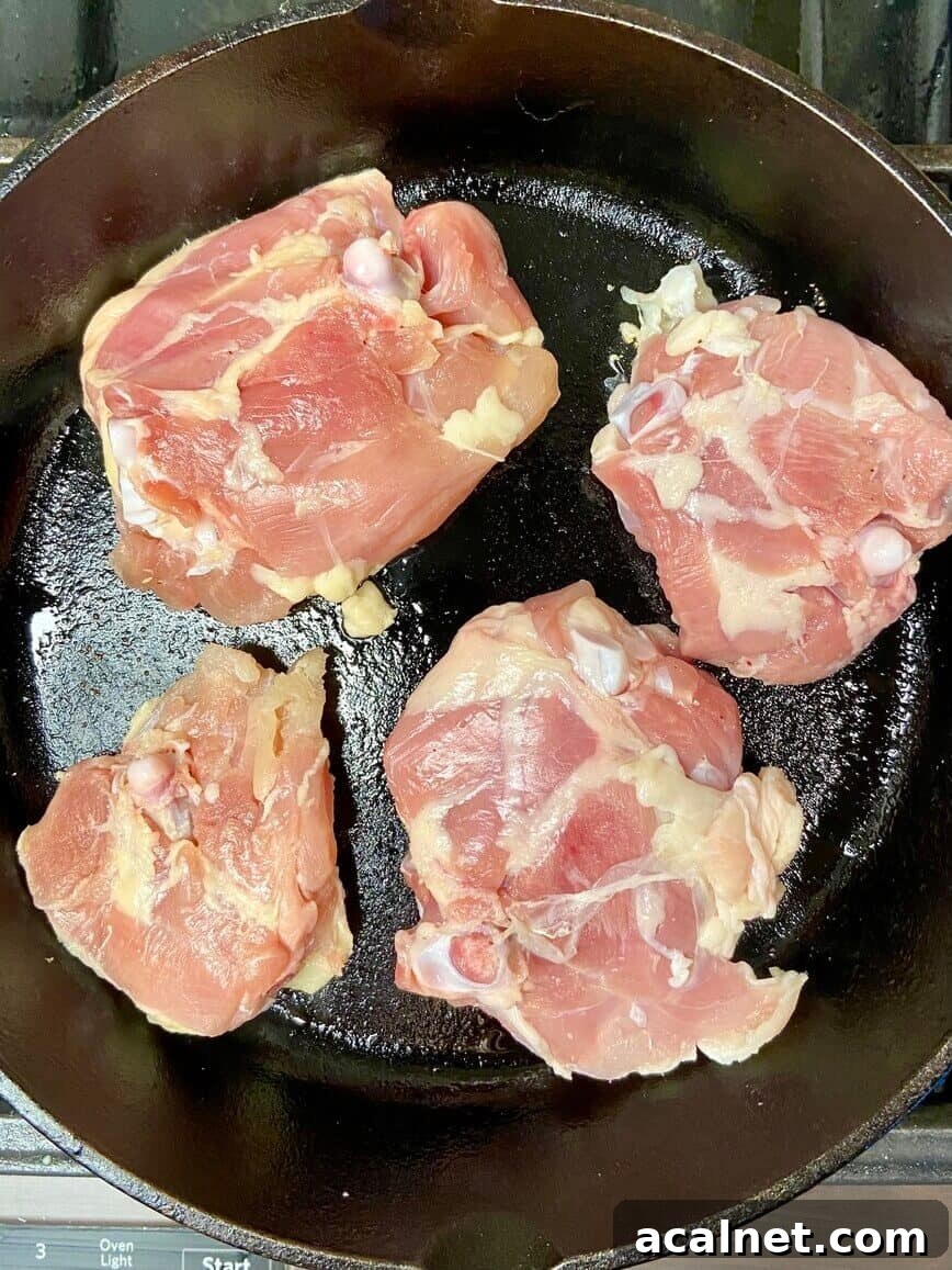Spicy Buffalo Chicken Thighs with Crispy Skin and Blue Cheese Dip 4 Cooking chicken in a cast iron pan.