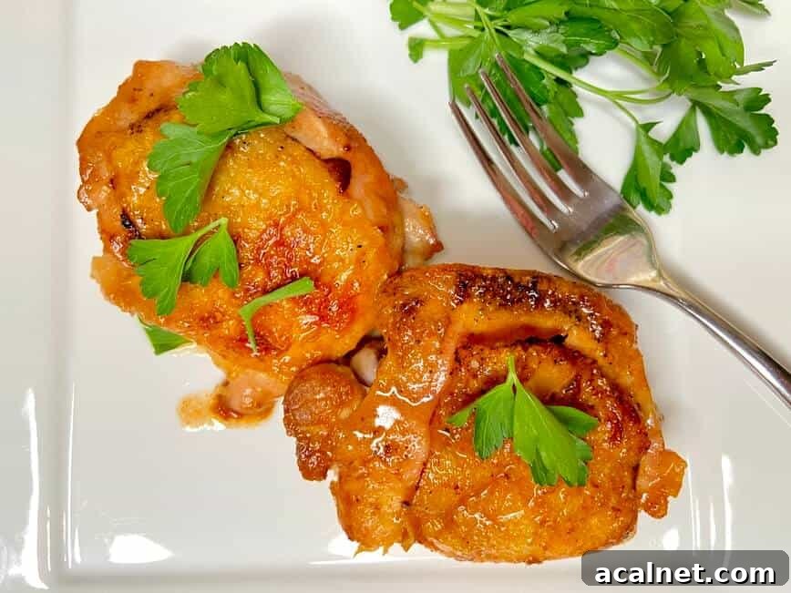Spicy Buffalo Chicken Thighs with Crispy Skin and Blue Cheese Dip 7 Served on a plate with a fork and fresh garden herbs.