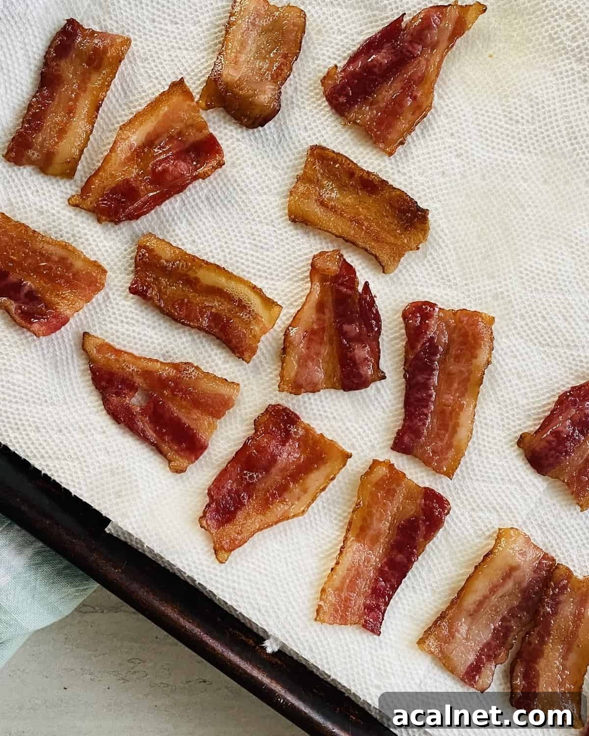 Draining grease of small pieces of bacon on paper towels.