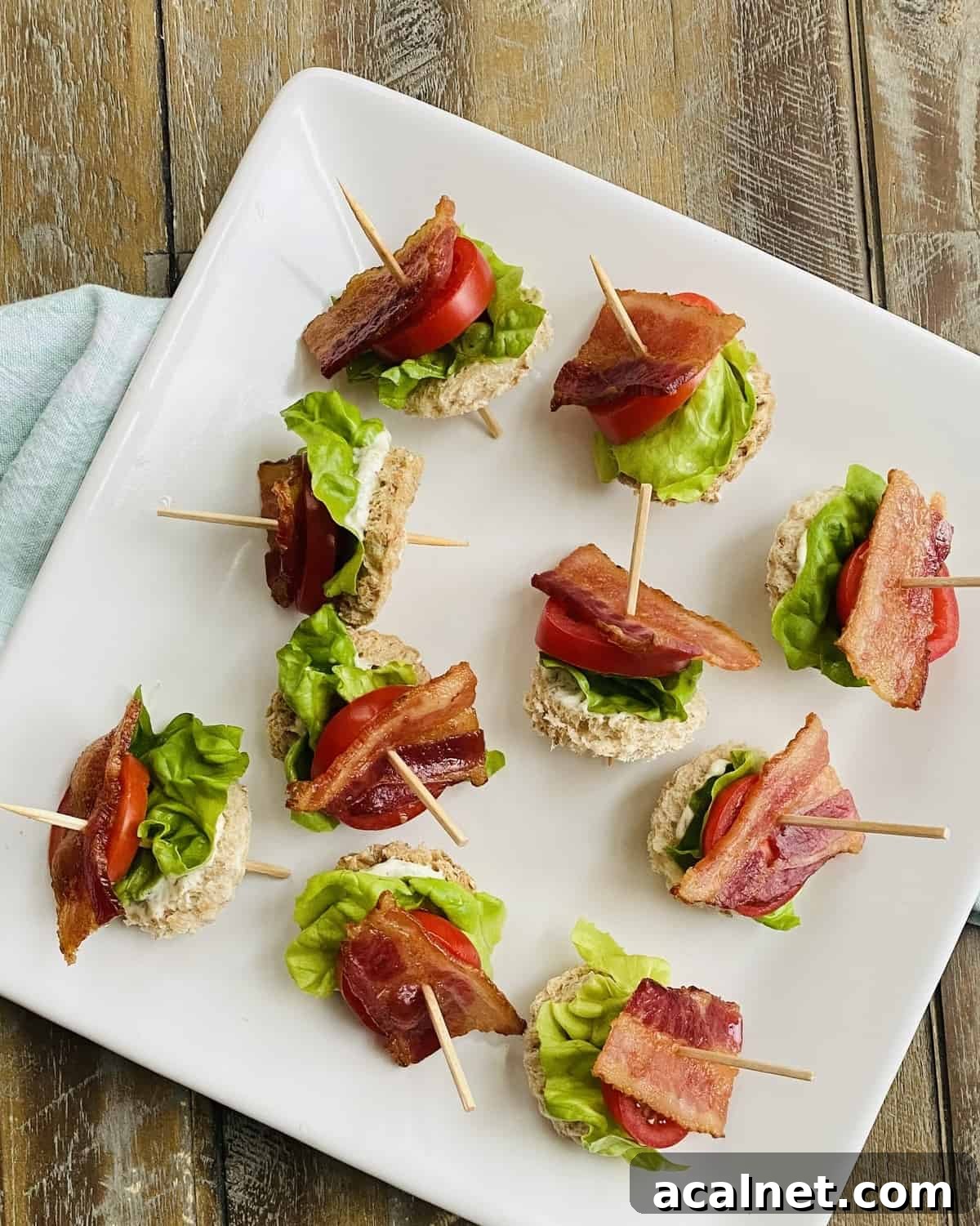 A platter of blt appetizers on toothpicks.