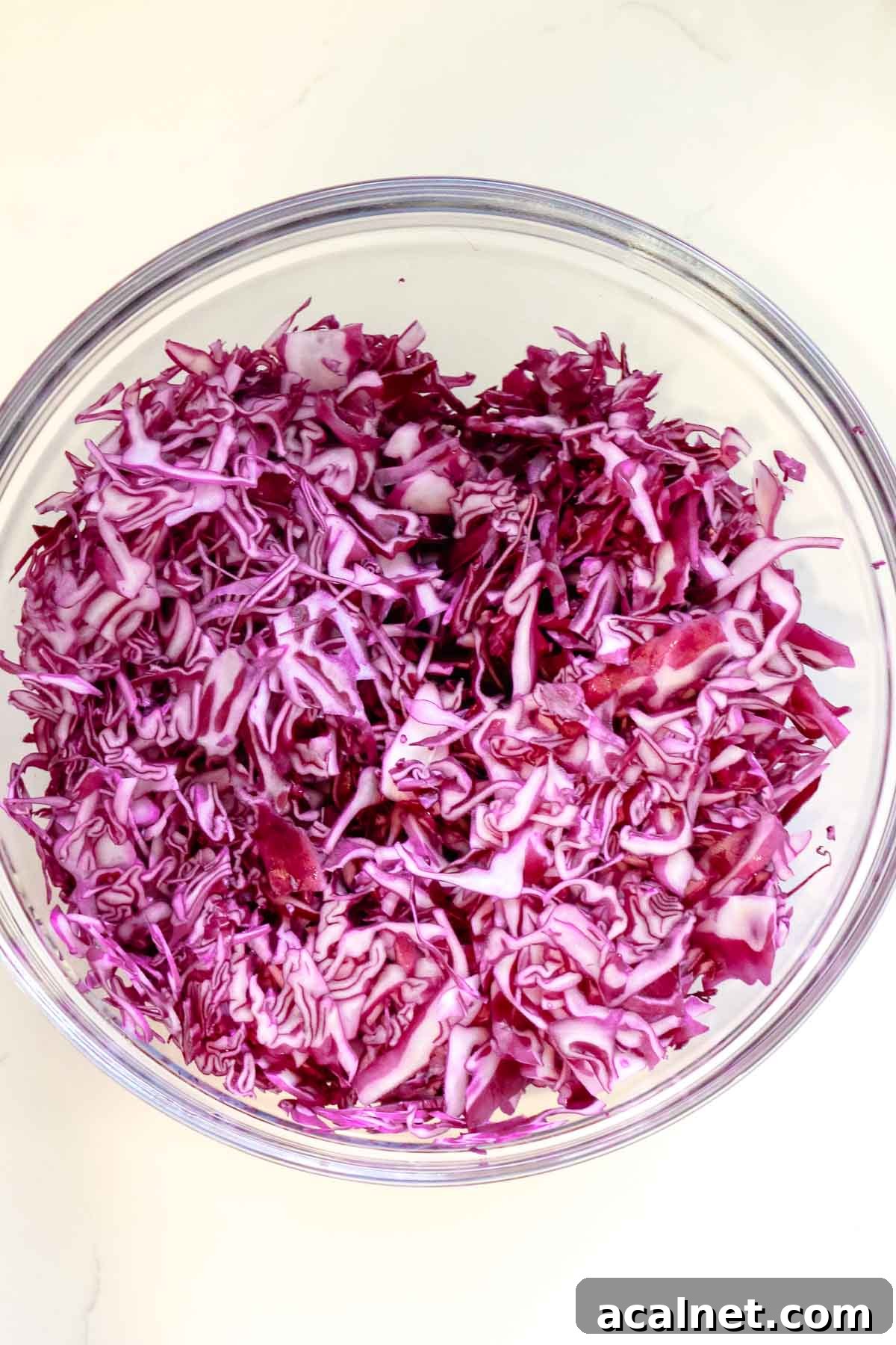 shredded red cabbage in a large glass bowl
